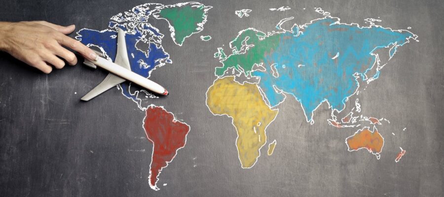 person with toy airplane on world map