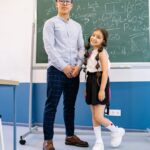 man in dress shirt standing beside a girl