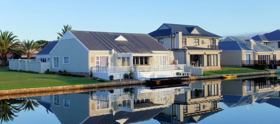 white single story houses beside body of water