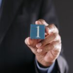 a close up shot of a person holding a block with a number