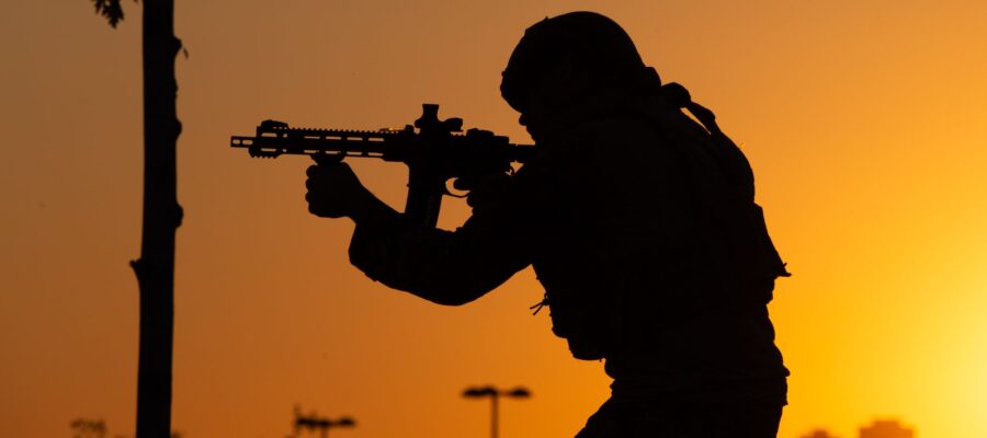 silhouette of man with gun at golden hour