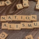 scrabble tiles spelling the word nation alism