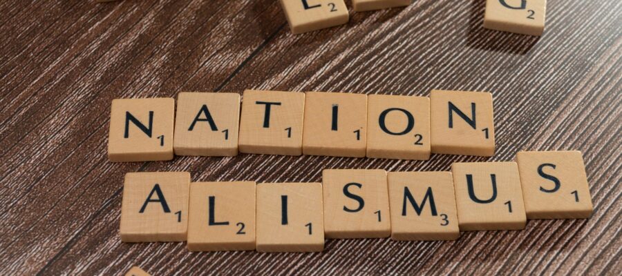 scrabble tiles spelling the word nation alism