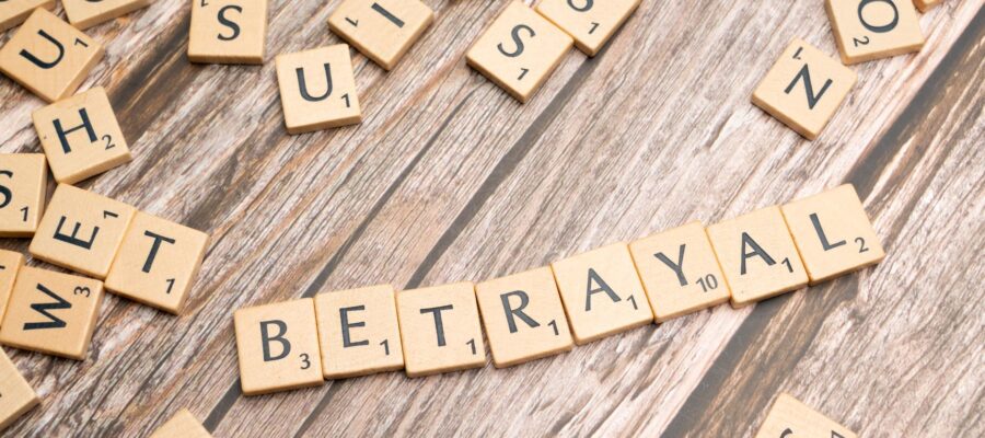 the word betrayal spelled out in scrabble tiles