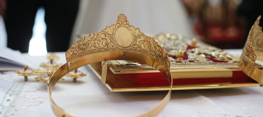 intricate golden wedding crowns on altar table
